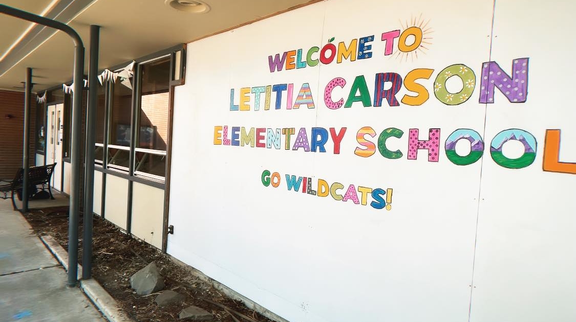 A colorful sign near the front entrance reading Letitia Carson Elementary, Go Wildcats!
